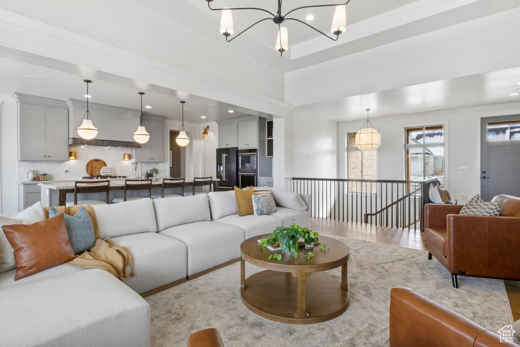 Living room with a notable chandelier and light hardwood / wood-style floors