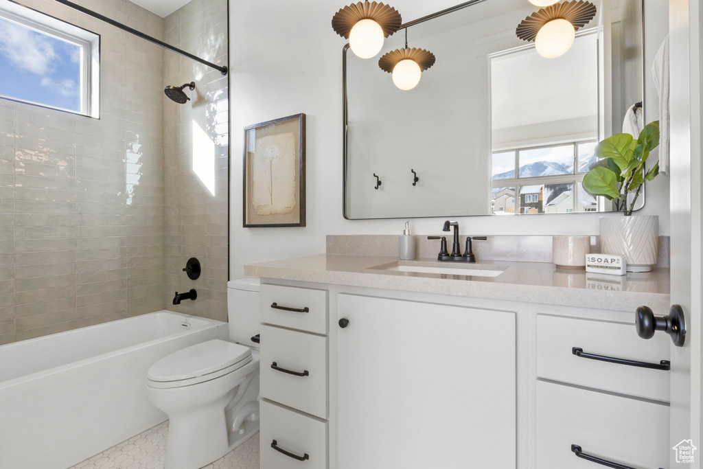 Full bathroom with vanity, toilet, and tiled shower / bath combo