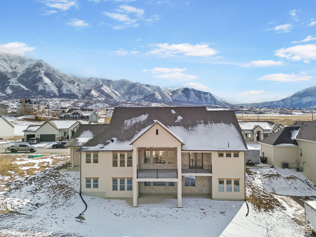 Snow covered house with central AC unit and a mountain view