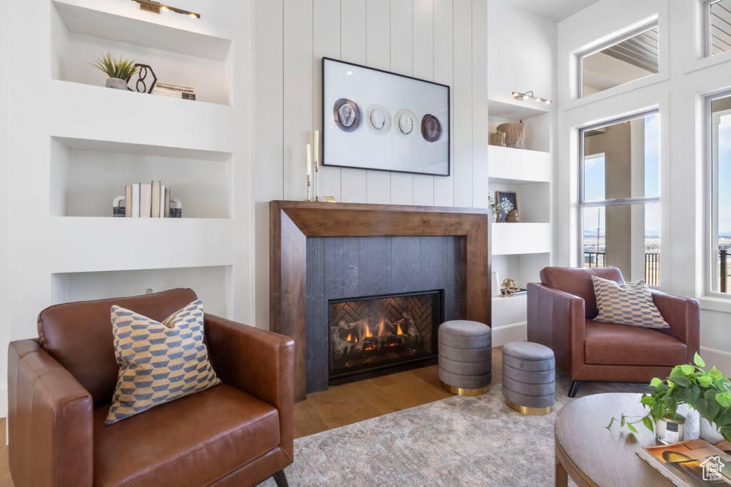 Living room with light hardwood / wood-style floors and built in features