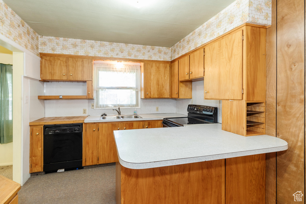 Kitchen featuring carpet floors, black appliances, kitchen peninsula, and sink