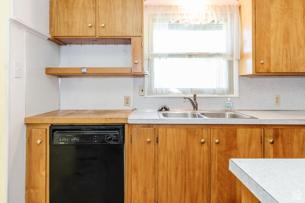 Kitchen featuring black dishwasher, plenty of natural light, sink, and decorative backsplash