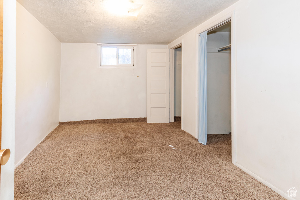 Interior space featuring a textured ceiling and carpet