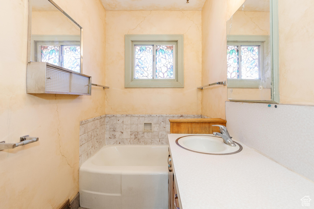 Bathroom featuring a bath and vanity