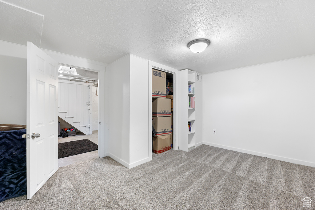 Spare room featuring a textured ceiling and carpet