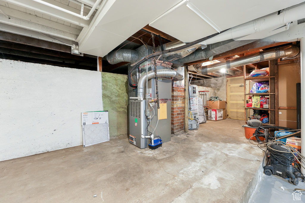 Basement featuring gas water heater and heating unit