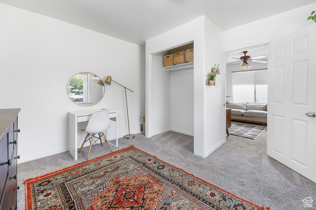 Carpeted entrance foyer featuring ceiling fan