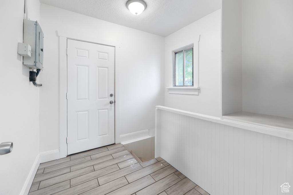 Foyer with electric panel and a textured ceiling