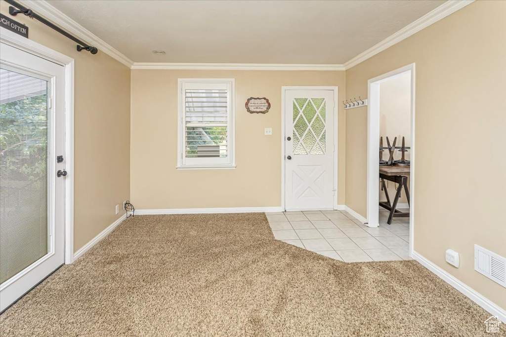 Carpeted entryway with ornamental molding