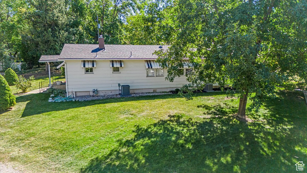 Exterior space with central AC unit and a lawn