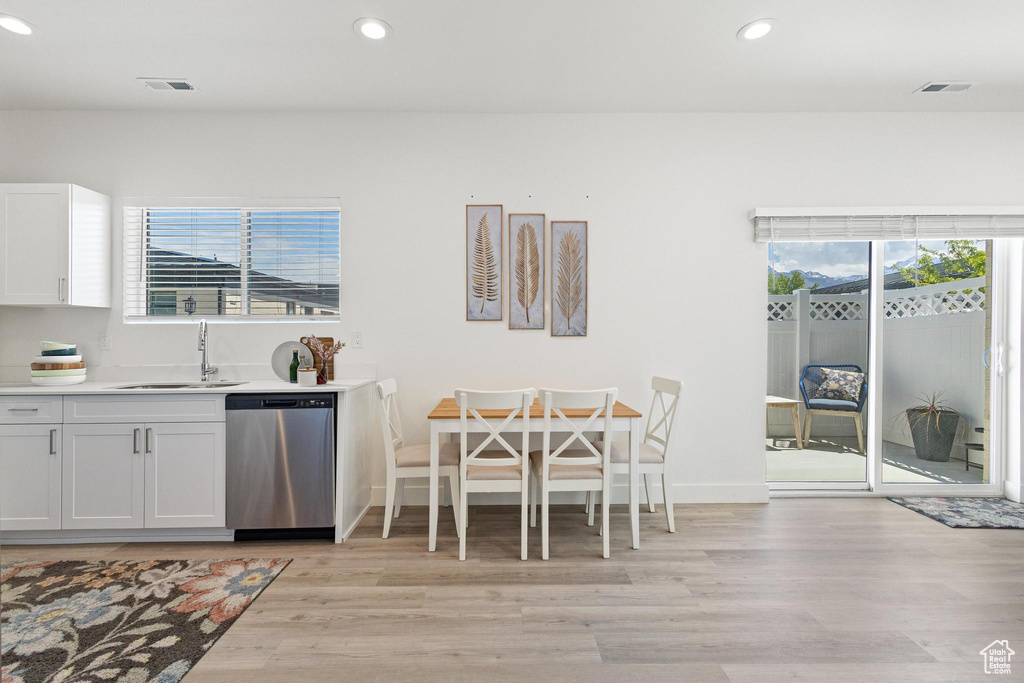 Kitchen featuring stainless steel dishwasher, visible vents, recessed lighting, a sink, and light wood-style flooring
