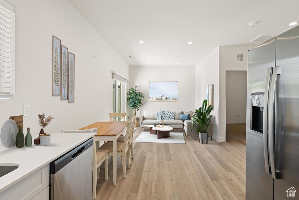 Kitchen with appliances with stainless steel finishes, light wood-style floors, light countertops, recessed lighting, and visible vents