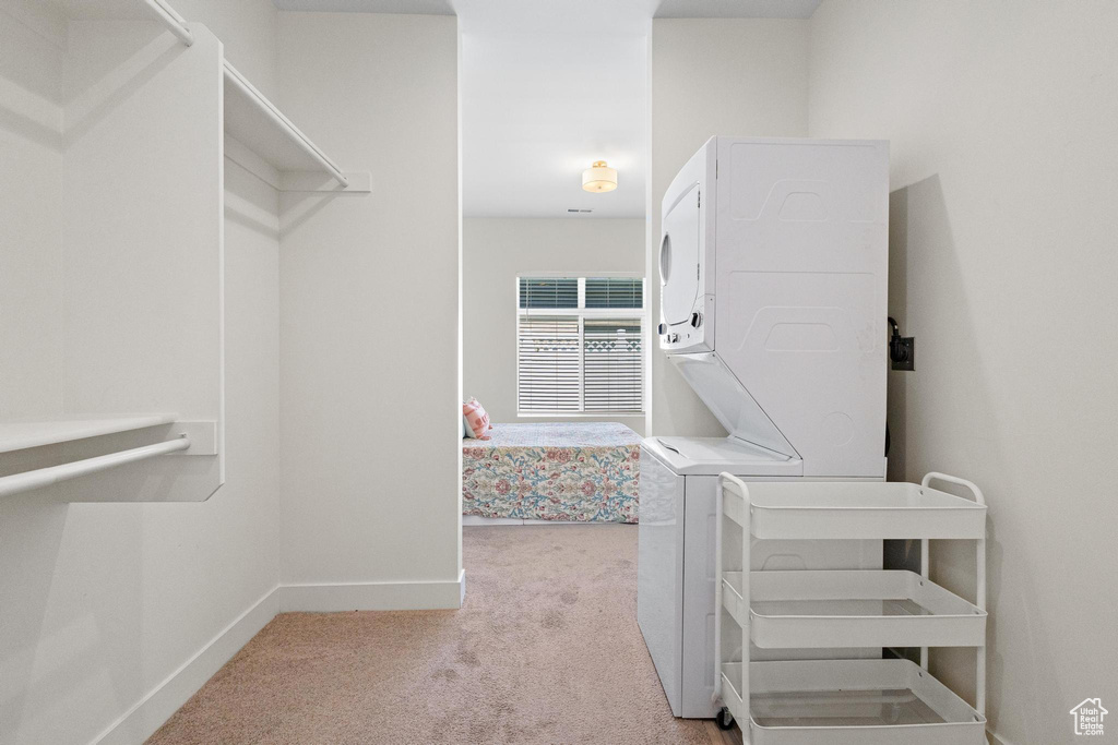 Spacious closet featuring carpet floors and stacked washer and dryer