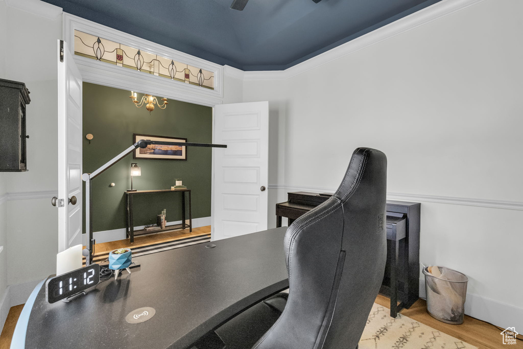 Home office with crown molding, light hardwood / wood-style floors, and a notable chandelier