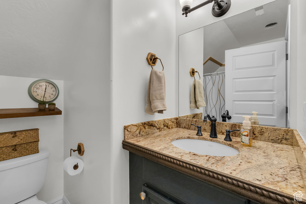 Bathroom with a shower with shower curtain, vanity, and toilet