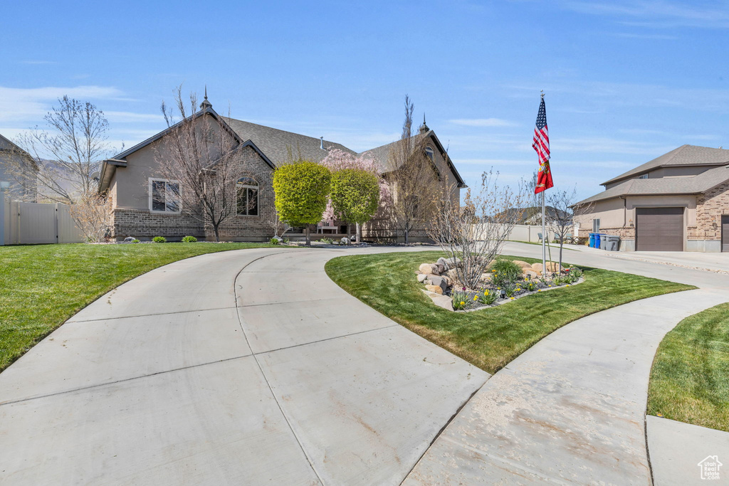 View of front of property with a garage and a front lawn