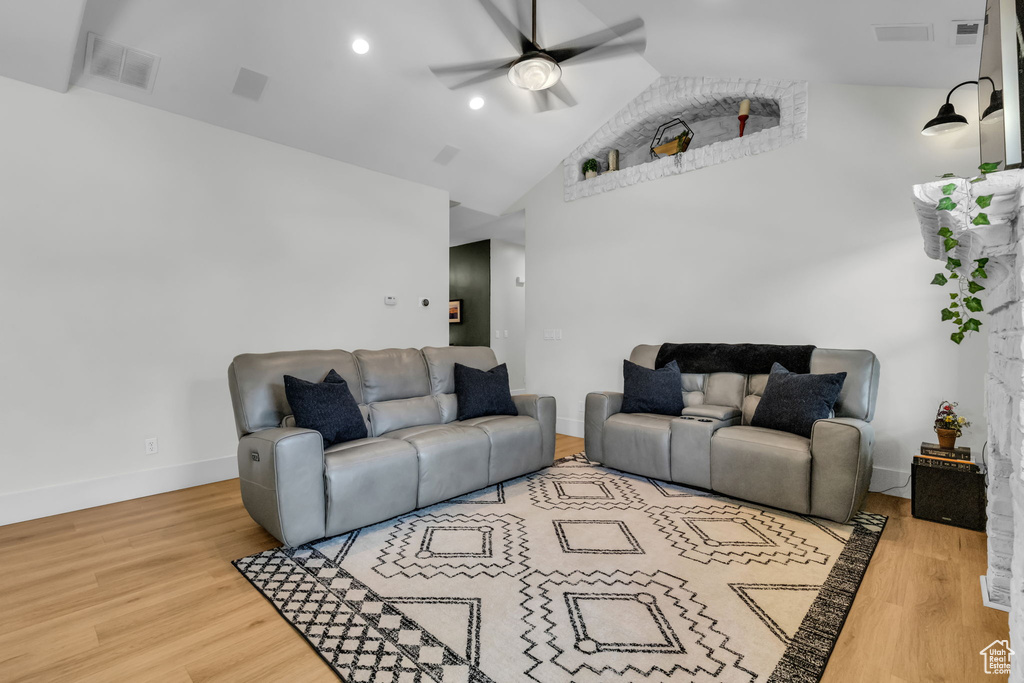 Living room with wood-type flooring, vaulted ceiling, and ceiling fan