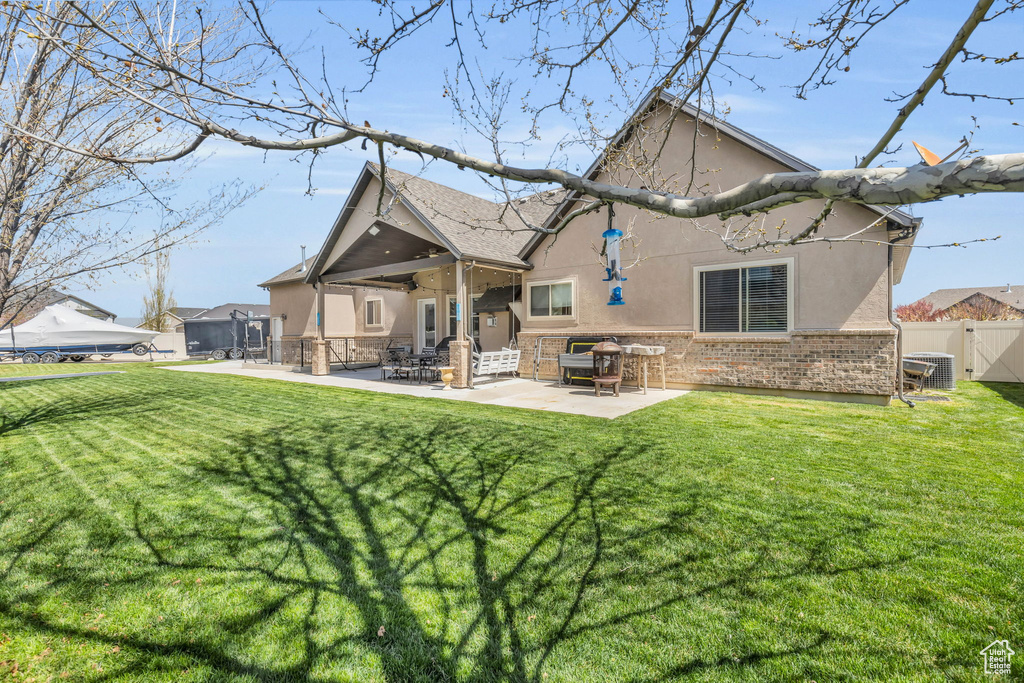 Back of house featuring a yard, a patio area, and central air condition unit