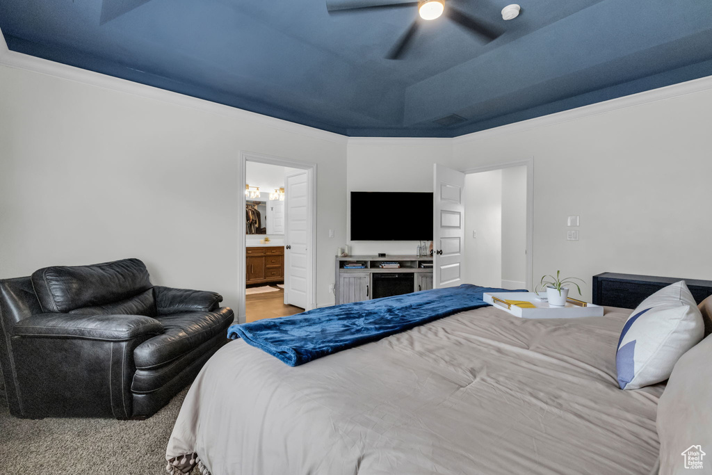 Carpeted bedroom featuring ceiling fan, ornamental molding, and ensuite bathroom