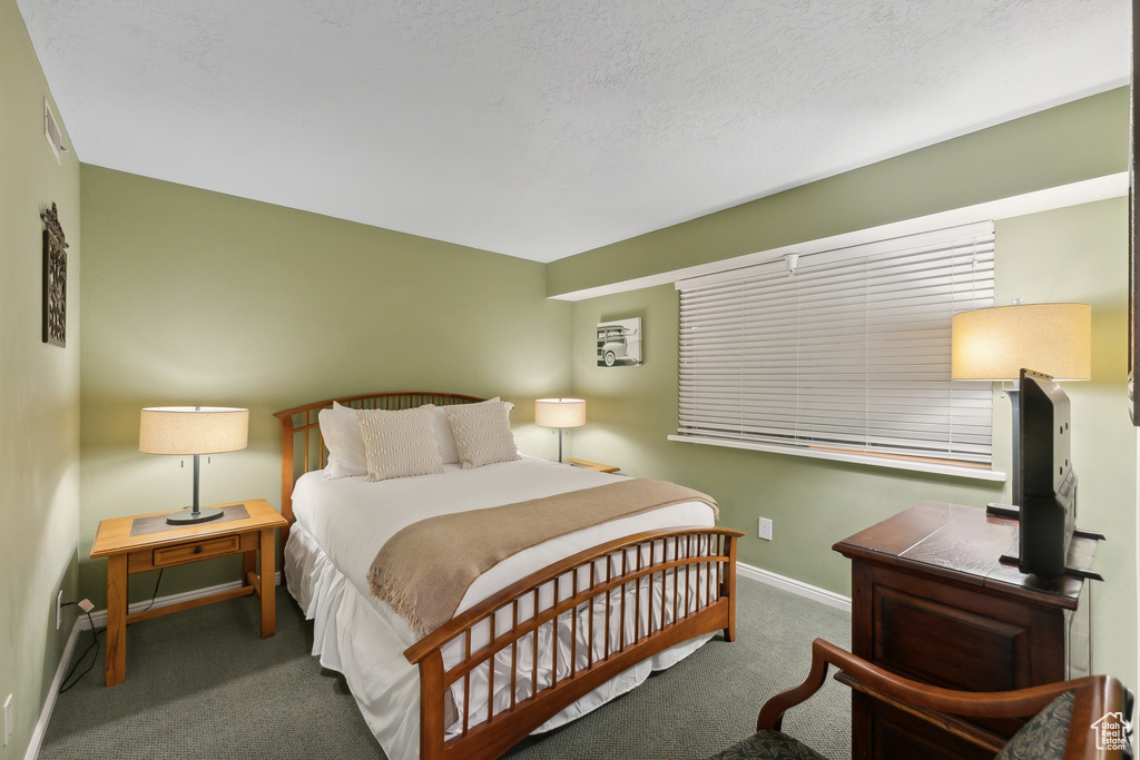 Bedroom with a textured ceiling and carpet flooring