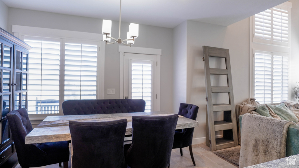 Dining space featuring a notable chandelier and light wood-type flooring