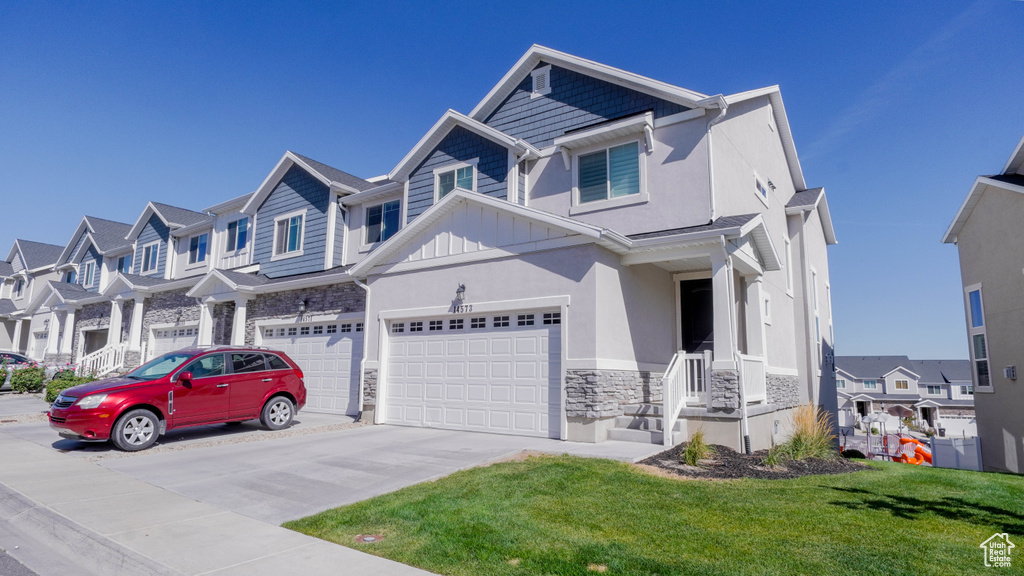 View of front of house with a front yard and a garage