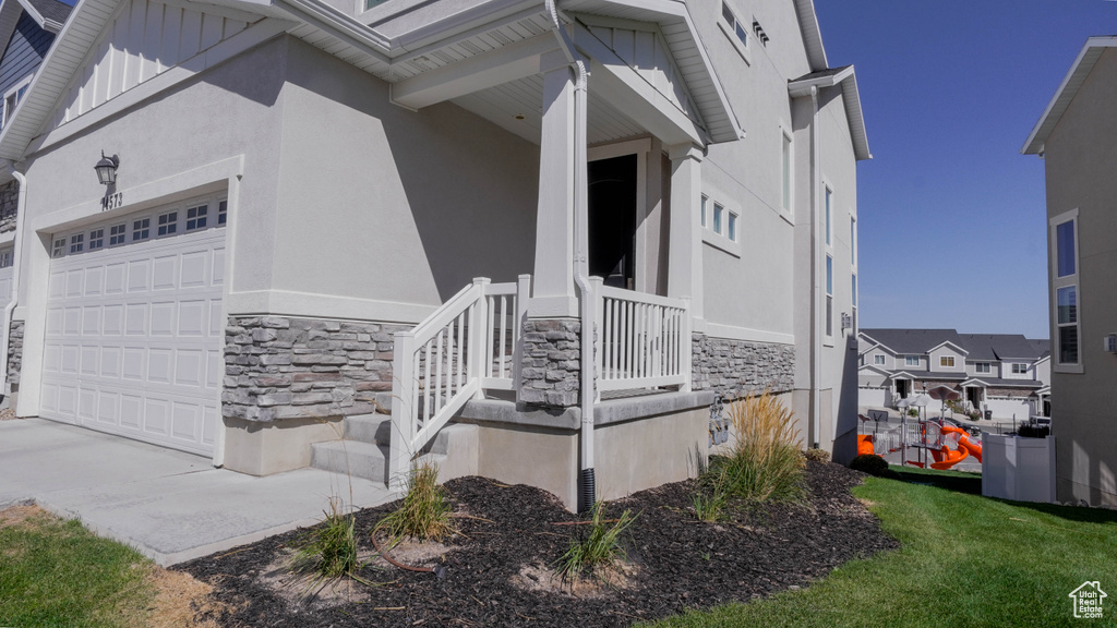 View of property exterior with a garage and a porch