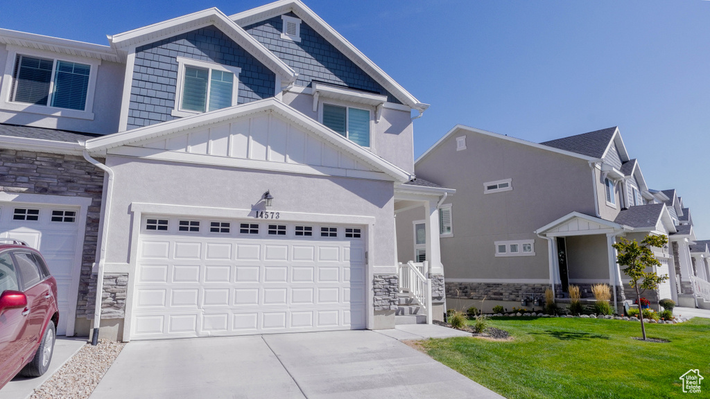 Craftsman-style house with a garage and a front yard