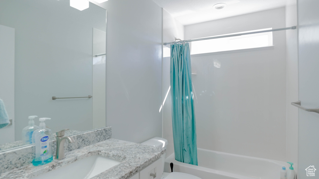 Full bathroom featuring shower / tub combo with curtain, vanity, and toilet