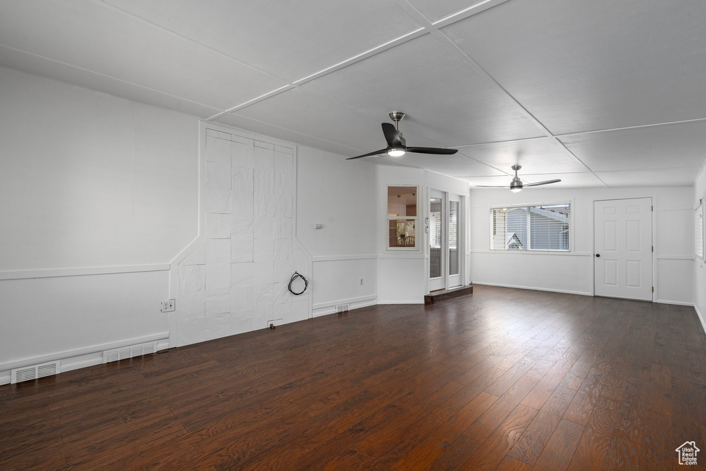 Empty room with ceiling fan and dark hardwood / wood-style floors