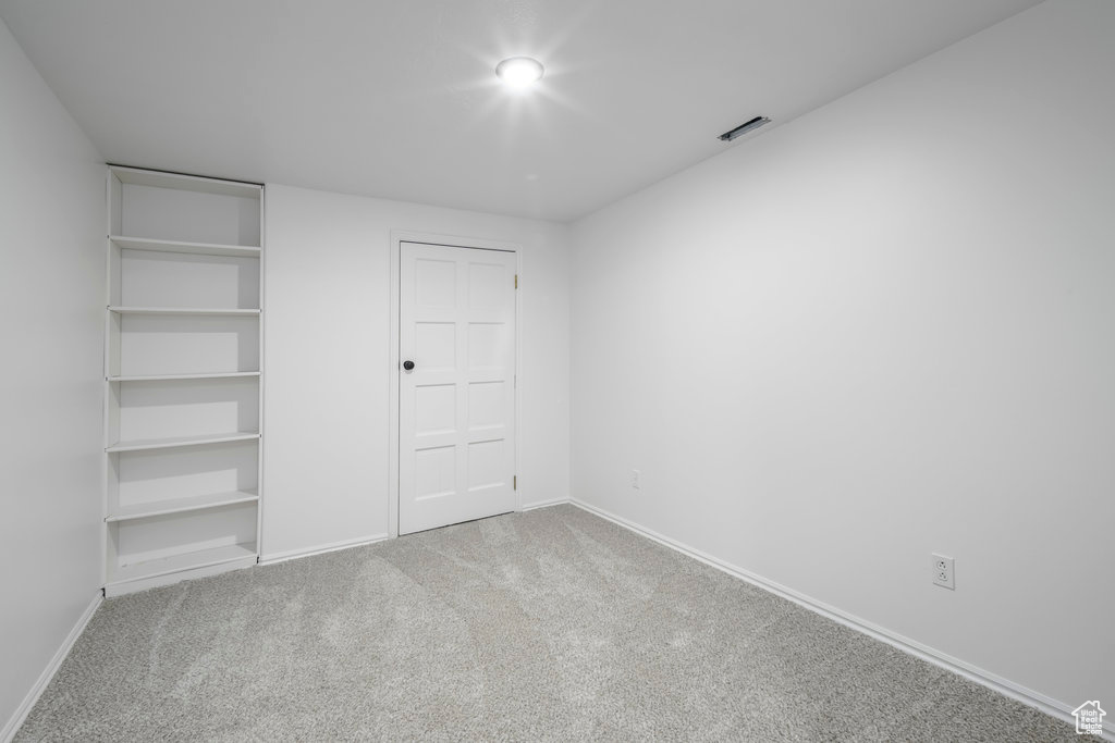 Unfurnished bedroom featuring light carpet and a closet