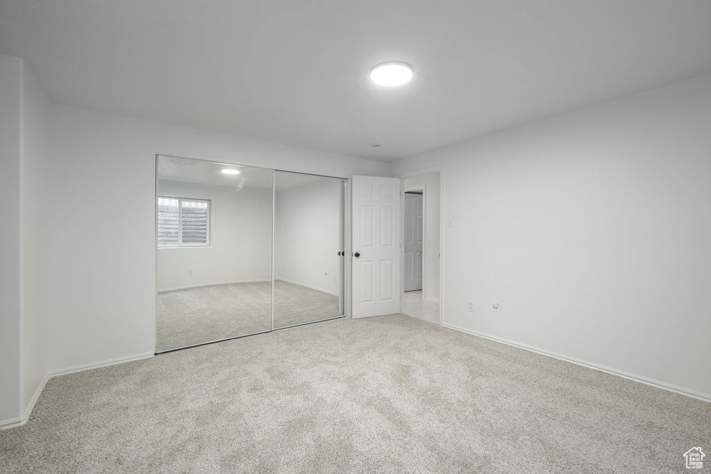 Unfurnished bedroom featuring a closet and carpet flooring