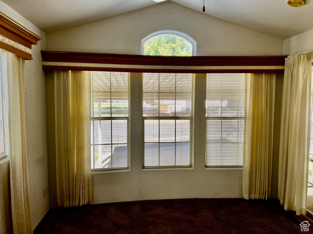 Carpeted empty room with lofted ceiling