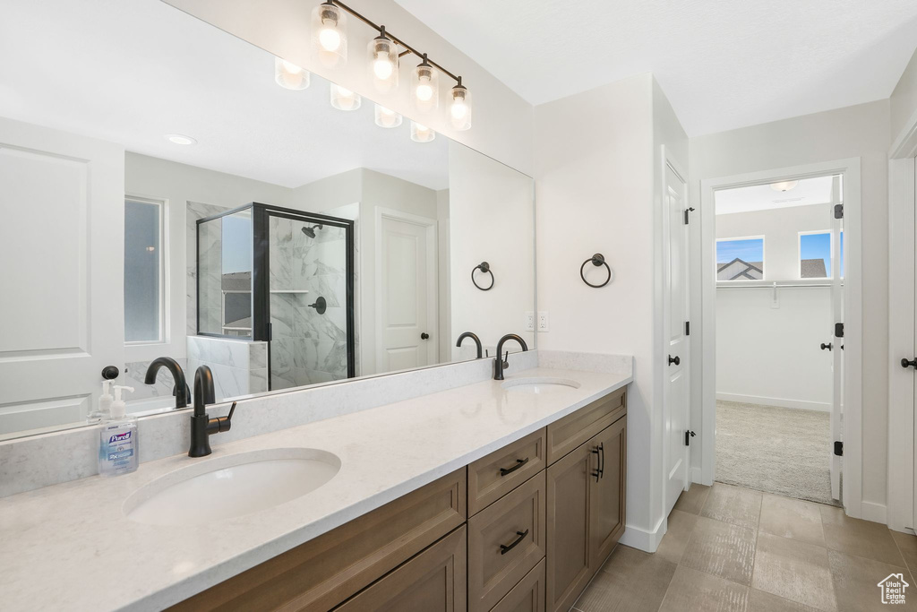 Bathroom with vanity, an enclosed shower, and tile patterned floors