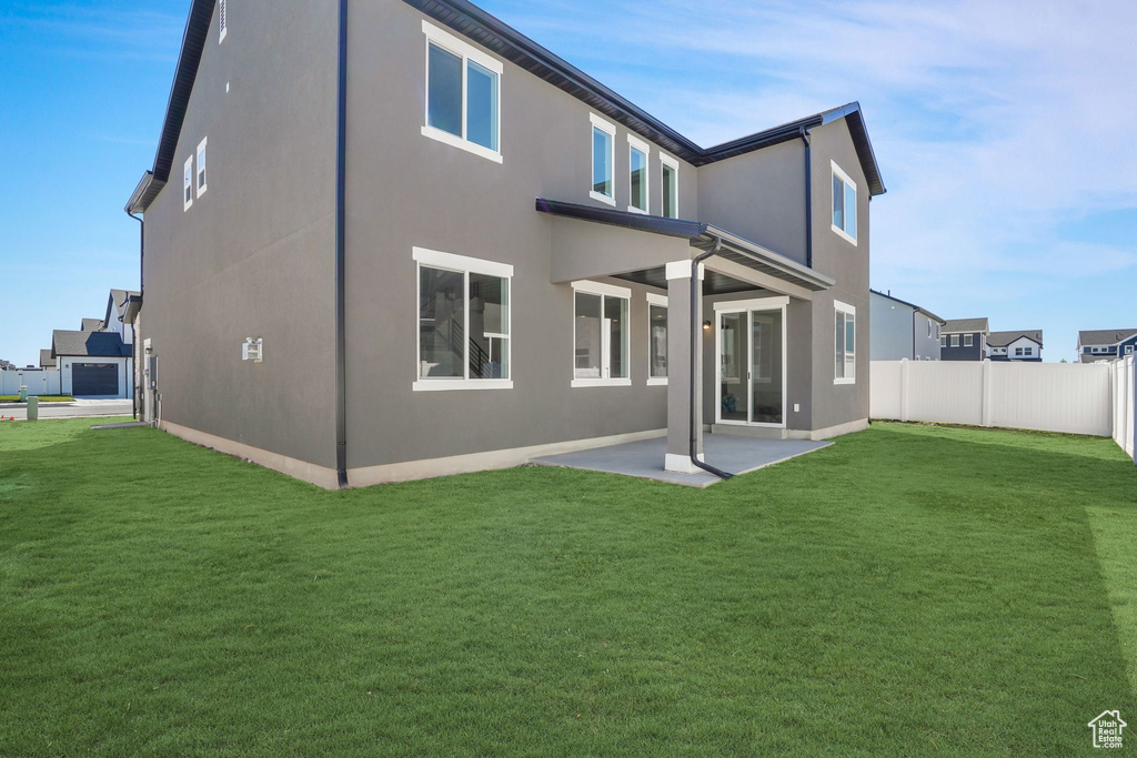 Rear view of property with a patio and a yard