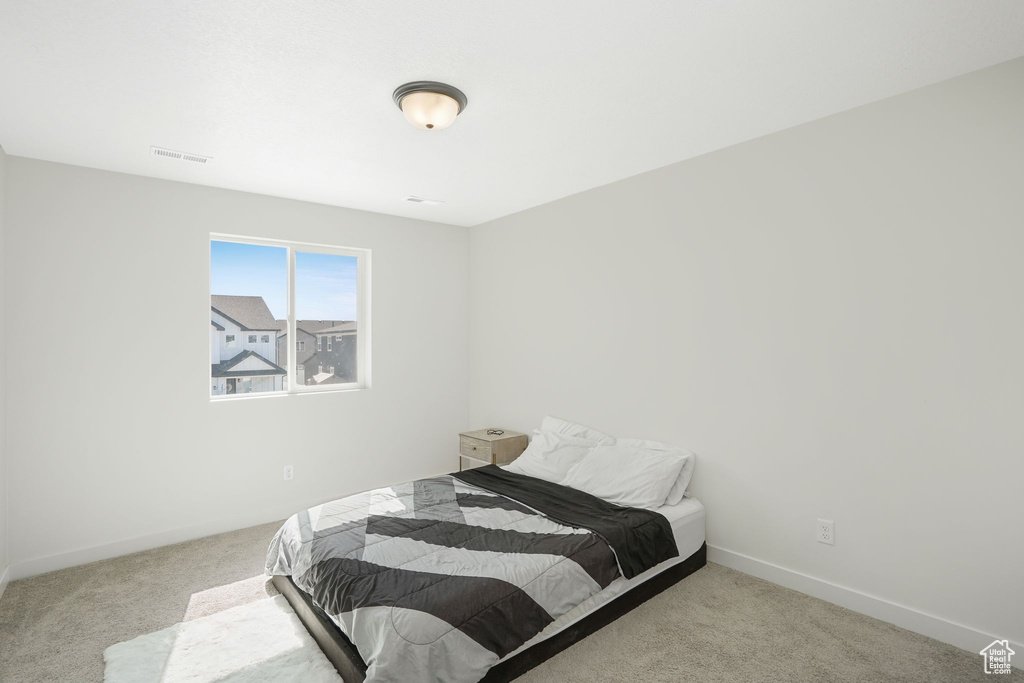 Bedroom featuring light carpet