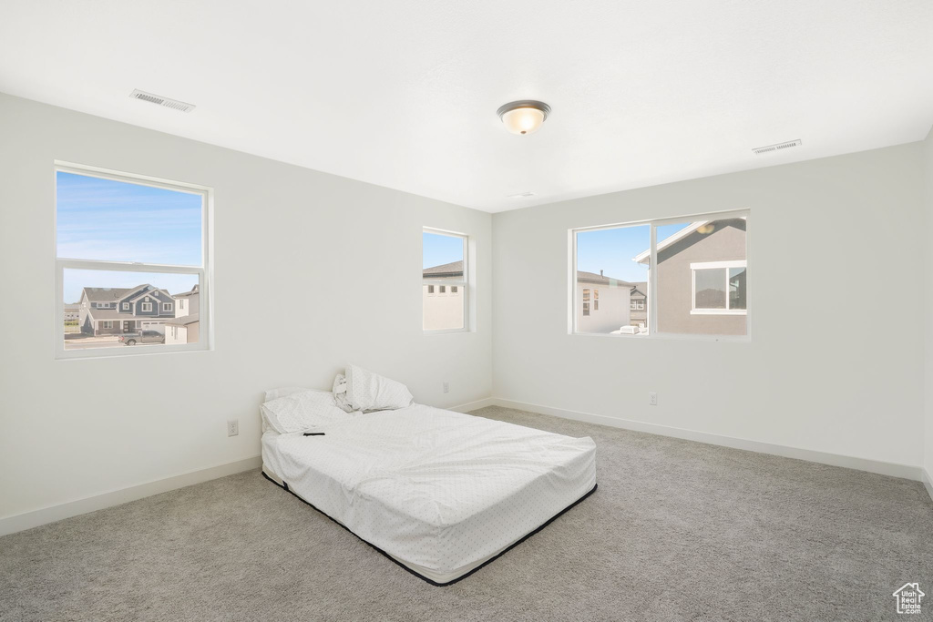 Bedroom featuring light carpet