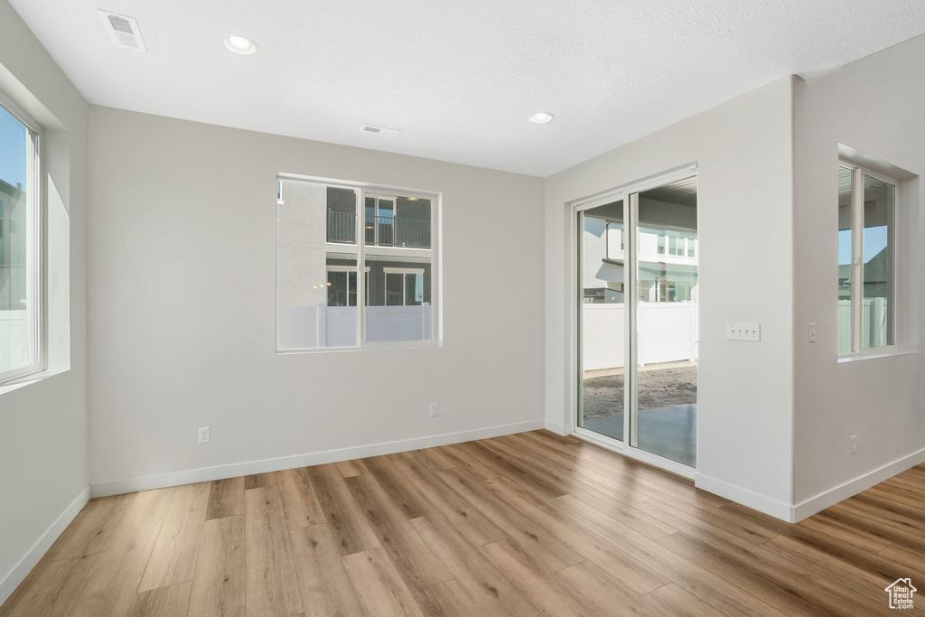 Empty room with light hardwood / wood-style floors