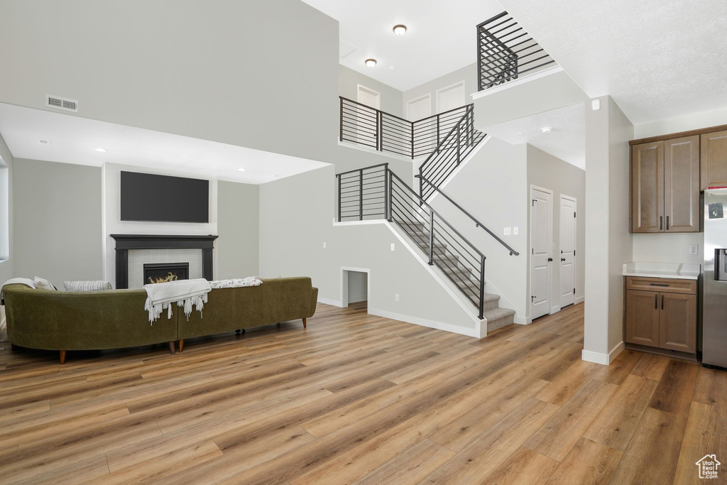 Living room featuring light wood-type flooring and a towering ceiling