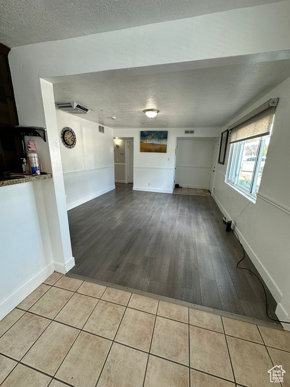 Unfurnished living room featuring light hardwood / wood-style floors and a textured ceiling