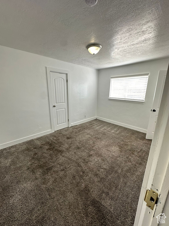 Carpeted spare room with a textured ceiling