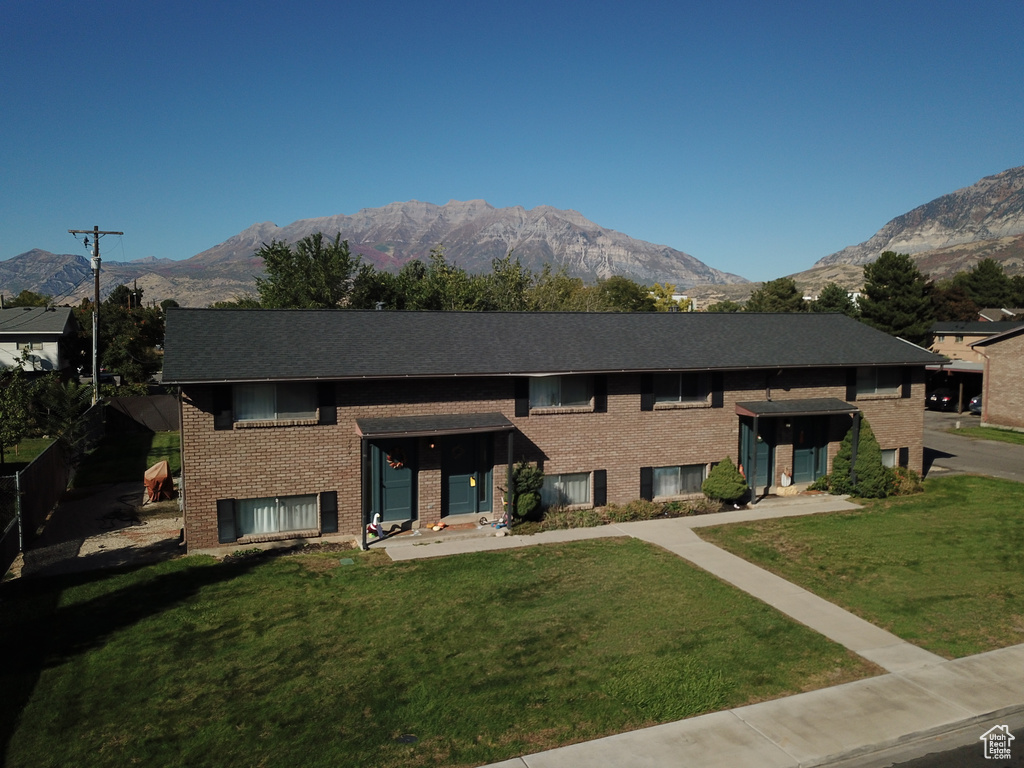 View of front of house featuring a mountain view and a front lawn