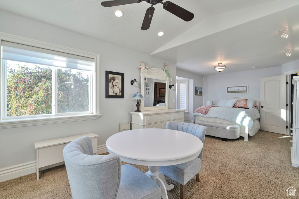 Carpeted bedroom featuring vaulted ceiling and ceiling fan