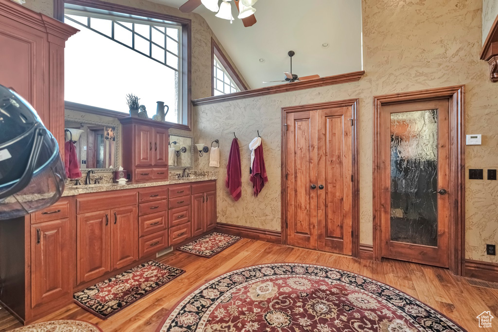 Bathroom with high vaulted ceiling, ceiling fan, and hardwood / wood-style flooring