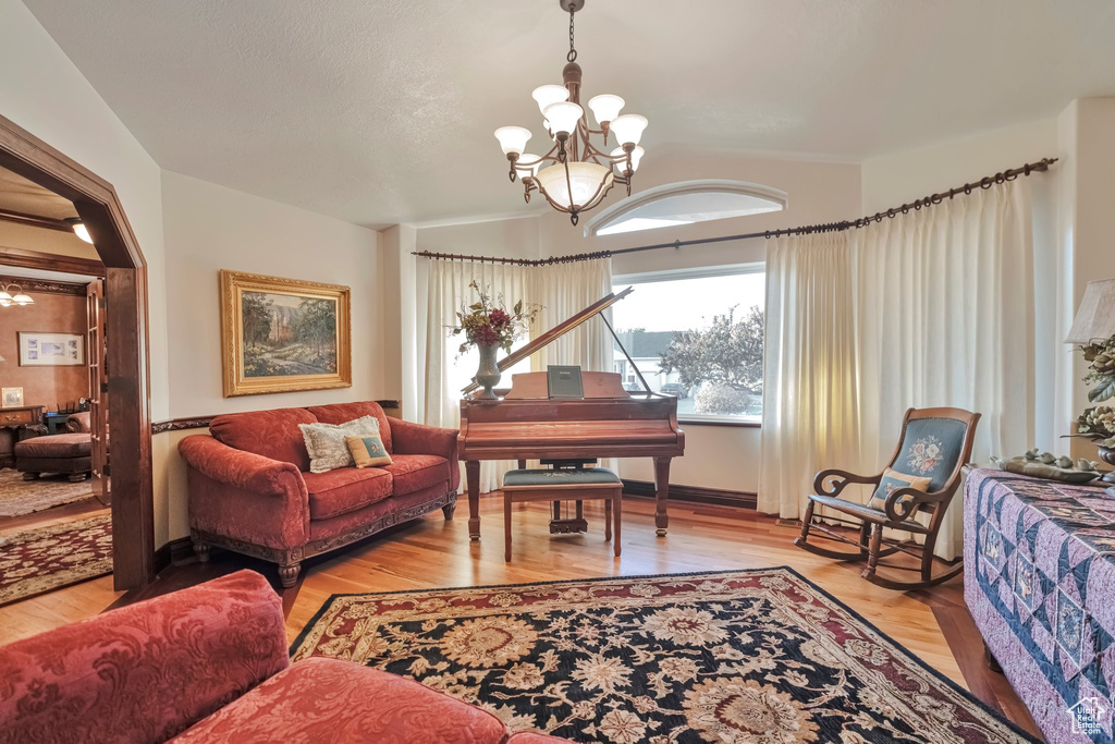 Living room with an inviting chandelier and light hardwood / wood-style flooring