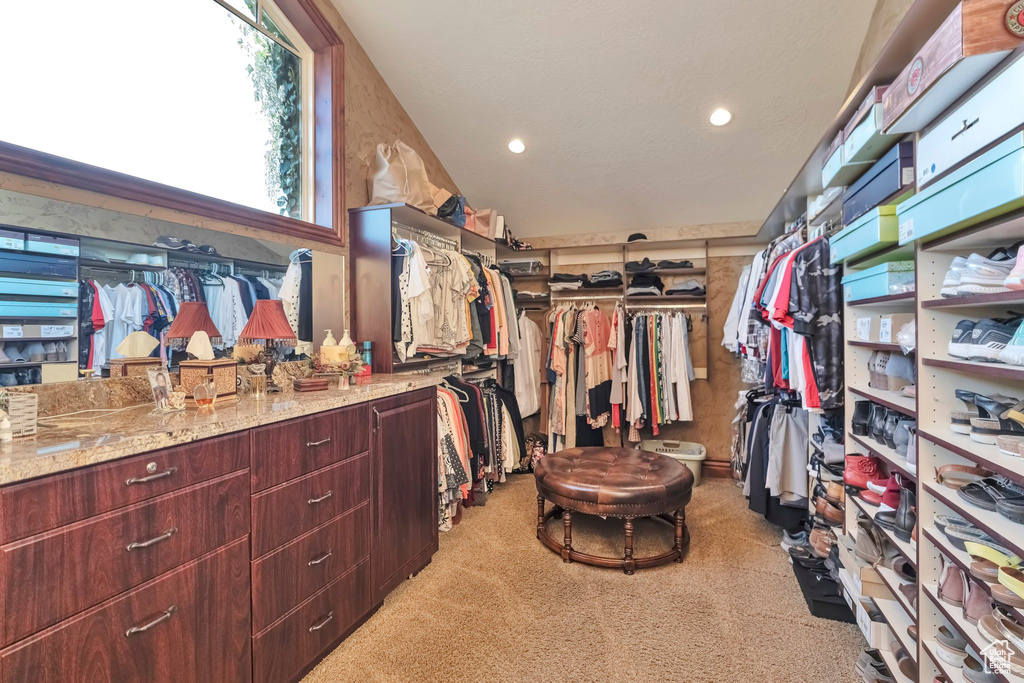 Walk in closet featuring light colored carpet