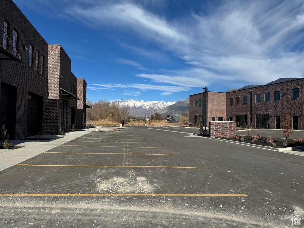 View of parking / parking lot with a mountain view and a garage