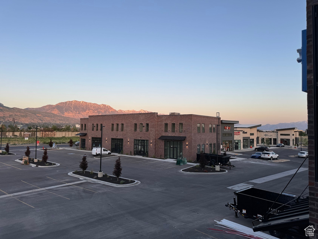 Property at dusk with a mountain view and uncovered parking