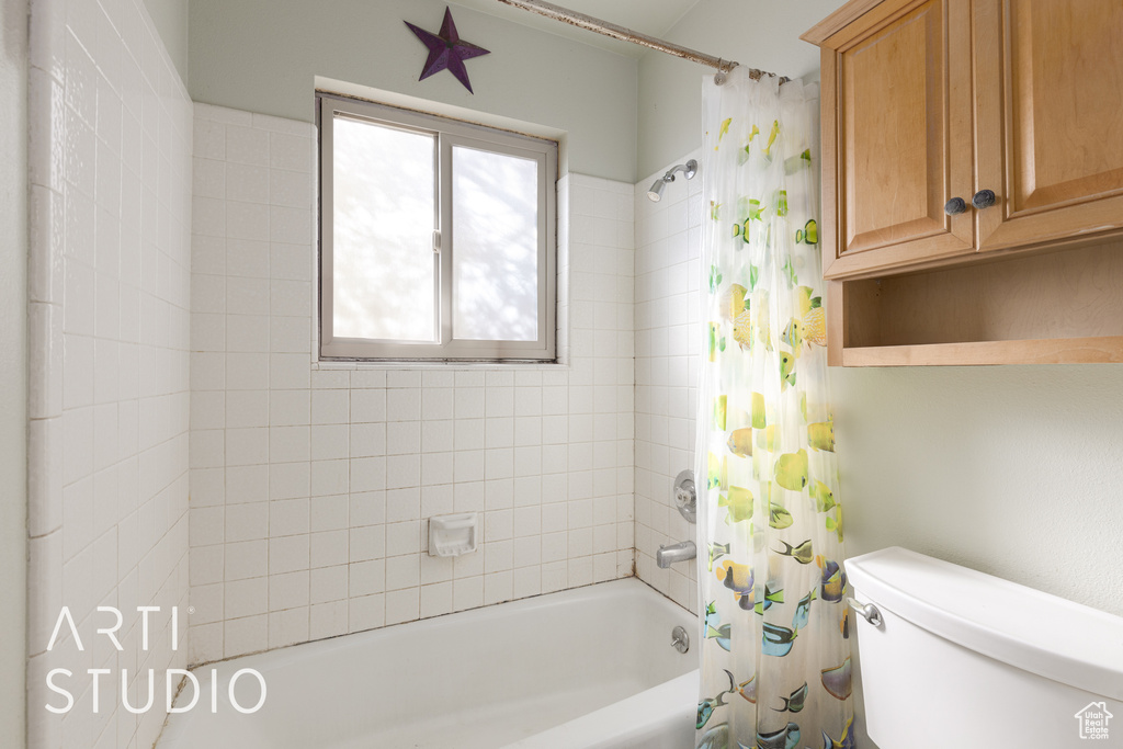 Bathroom with shower / tub combo and toilet