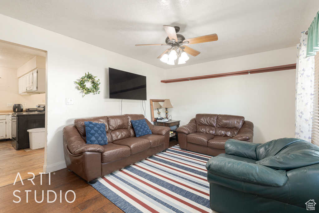 Living room featuring ceiling fan and dark hardwood / wood-style floors